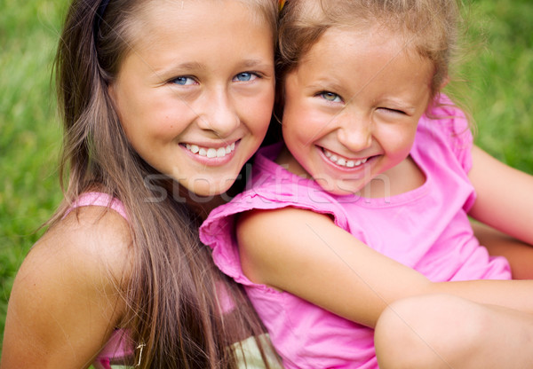 Stock photo: Fine picture of two cute sisters resting in the garden