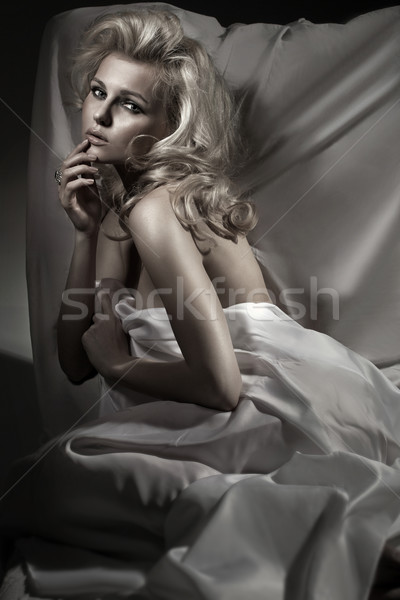 Gorgeous blonde woman covered by bedding Stock photo © konradbak