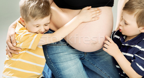 Little sons stroking pregnant mother's belly Stock photo © konradbak
