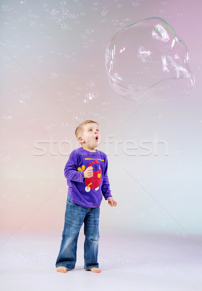 Cute little boy enjoying soap bubbles Stock photo © konradbak