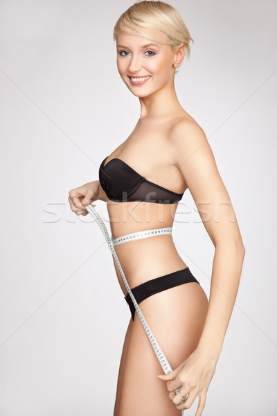 Young beautiful woman with measure tape on white Stock photo © konradbak