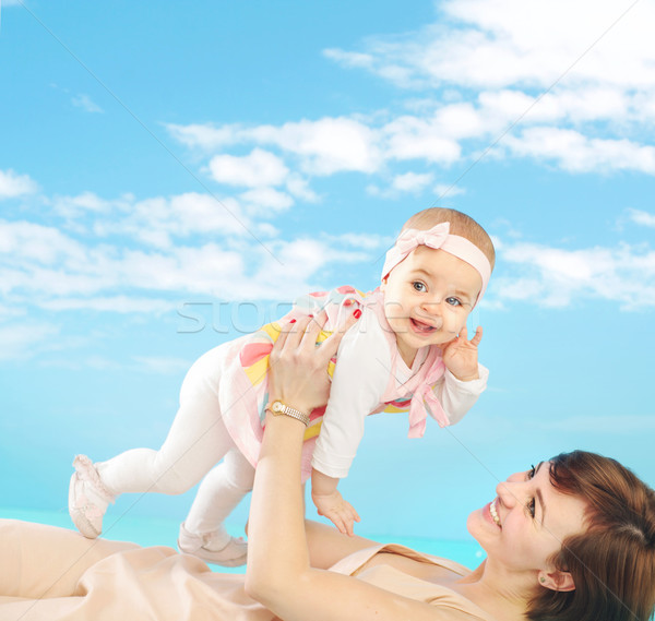 Attractive mom holding her tiny daughter Stock photo © konradbak