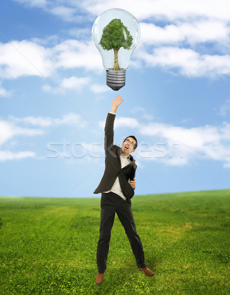Businessman reaching green energy symbol  Stock photo © konradbak