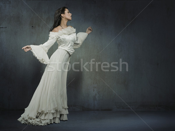 Beautiful woman wearing white dress over a grungy wall Stock photo © konradbak