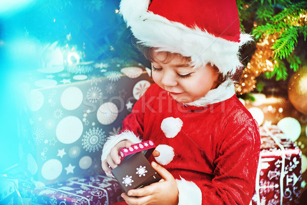 Little santa kid checking the gift Stock photo © konradbak