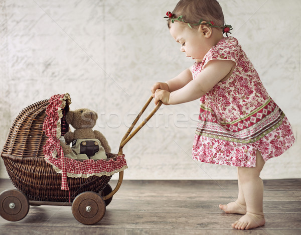 Little girl playing the toy carriage Stock photo © konradbak