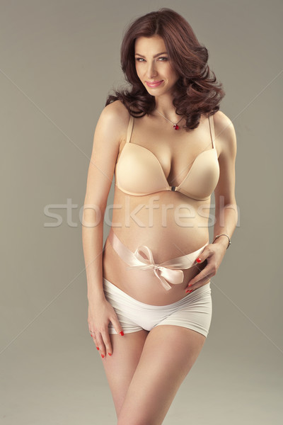 Brunette pretty woman stroking her belly Stock photo © konradbak