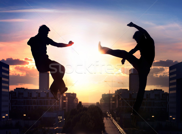 Two capoeira fighters over city background Stock photo © konradbak