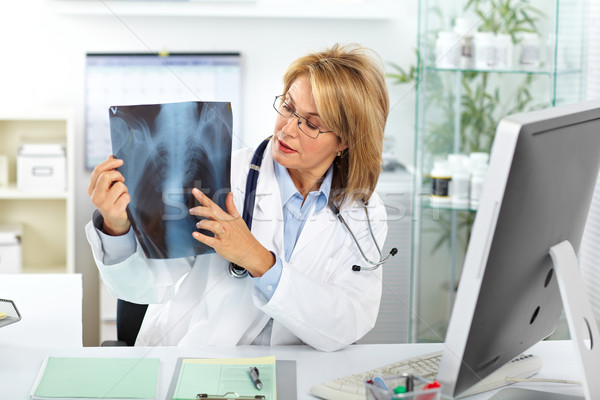 Stock photo: Mature doctor woman with a X-ray photograph.