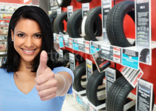 Auto dealer woman near a car tire. Stock photo © Kurhan