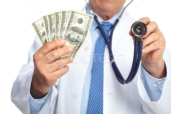 Hands of medical doctor with money. Stock photo © Kurhan