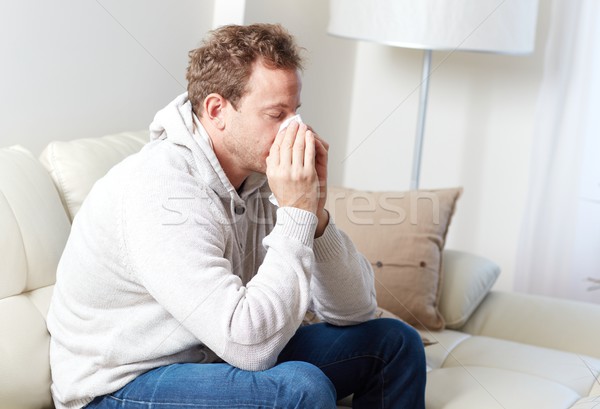 Krank Mann kalten Grippe Sitzung Sofa Stock foto © Kurhan