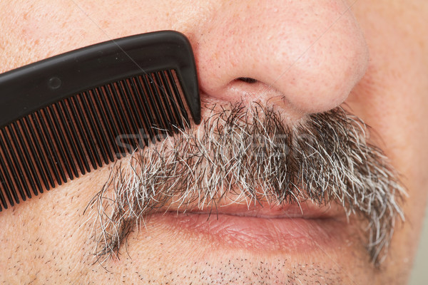 Stock photo: Man combing his mustache.