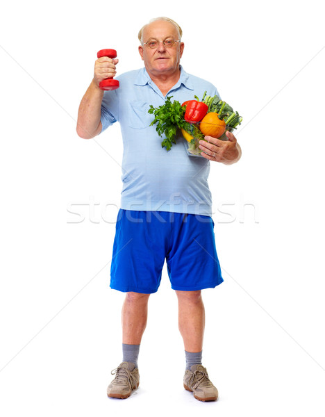 Senior man with dumbbell and vegetables. Stock photo © Kurhan