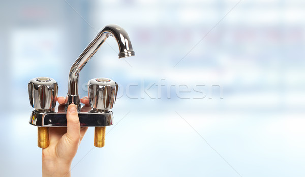 Hand of plumber with a water tap. Stock photo © Kurhan