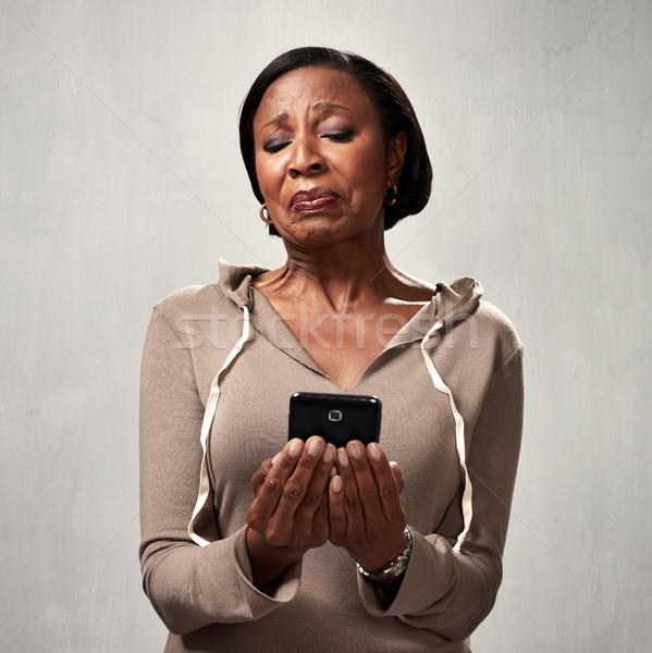 Stock photo: discontented woman with smartphone