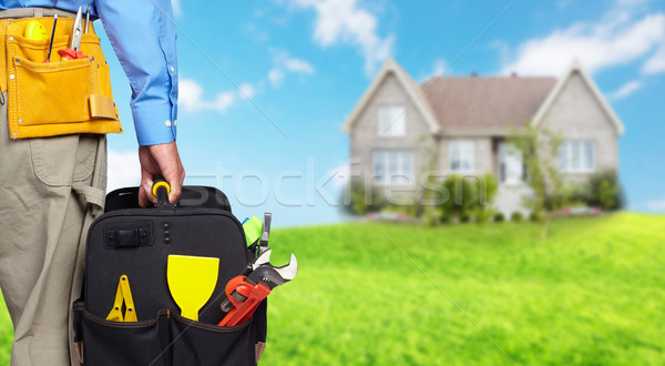 Hand of handyman with a tool bag. Stock photo © Kurhan