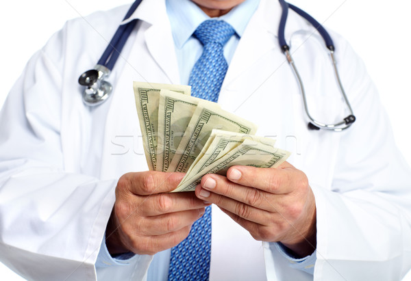 Hands of medical doctor with money. Stock photo © Kurhan