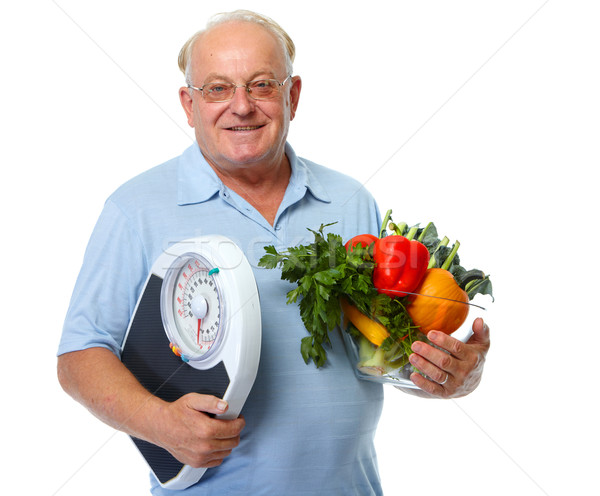 Senior man with scales and vegetables. Stock photo © Kurhan