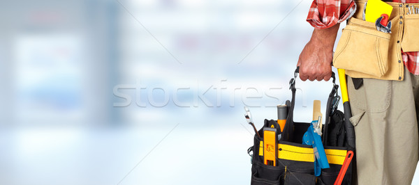 Hand of handyman with a tool bag. Stock photo © Kurhan