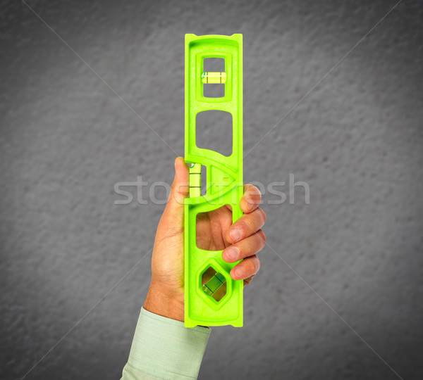 Hand of handyman with a construction level. Stock photo © Kurhan