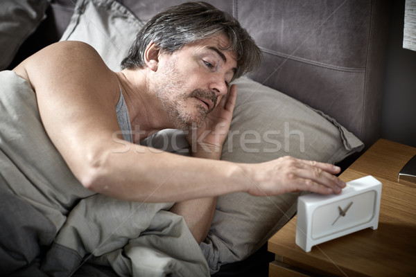 Sleepy man in bed wake up. Stock photo © Kurhan