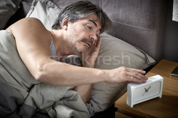 Foto stock: Soñoliento · hombre · cama · hasta · despertador