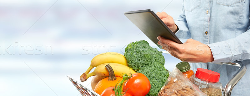 Woman with shopping cart and tablet computer. Stock photo © Kurhan