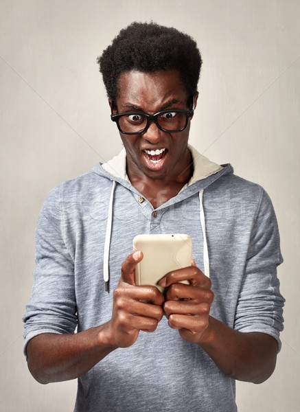 Homem negro surpreendido africano americano moço celular Foto stock © Kurhan