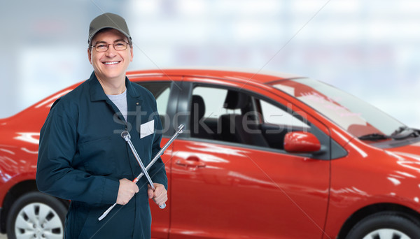 Stock photo: Auto mechanic with tire wrench in garage.