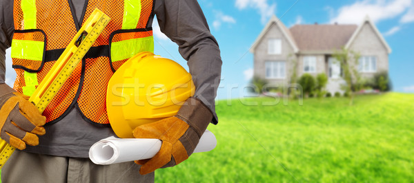 Stock photo: Worker with helmet in orange security vest.