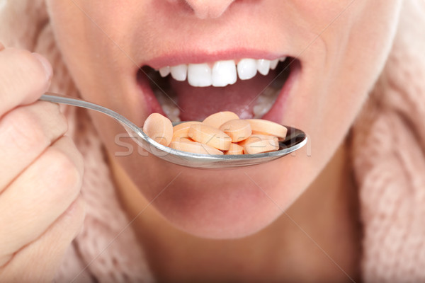 Woman mouth eating pills. Stock photo © Kurhan