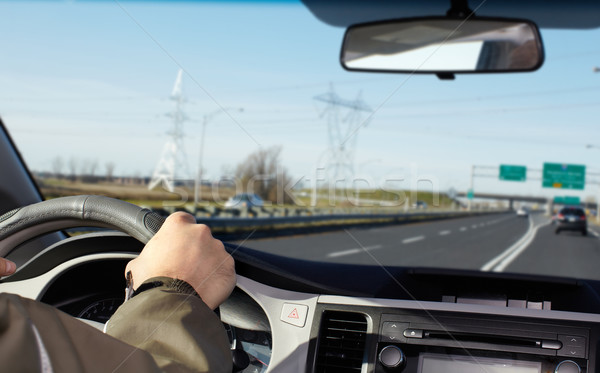 Hand of man driving on a highway. Stock photo © Kurhan