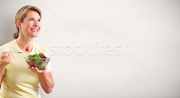 Stock photo: Elderly woman eating salad.