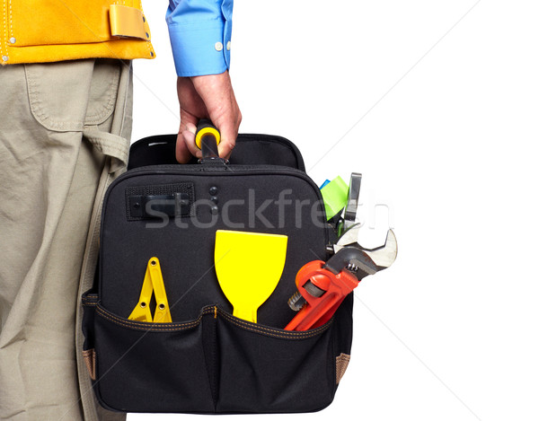 Hand of handyman with a tool bag. Stock photo © Kurhan