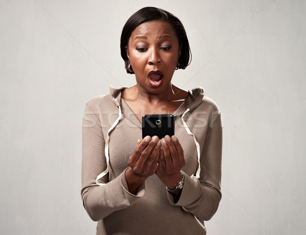 African surprised woman with smartphone Stock photo © Kurhan