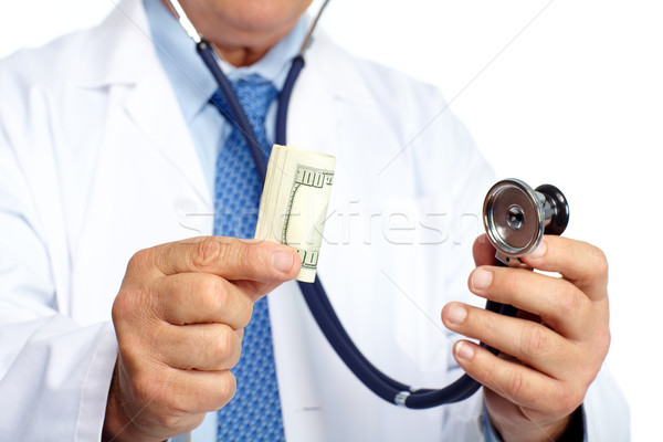 Hands of medical doctor with money. Stock photo © Kurhan