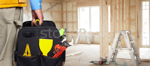 Hand of handyman with a tool bag. Stock photo © Kurhan