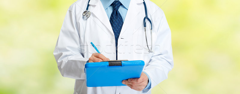 Doctor hands writing on clipboard Stock photo © Kurhan
