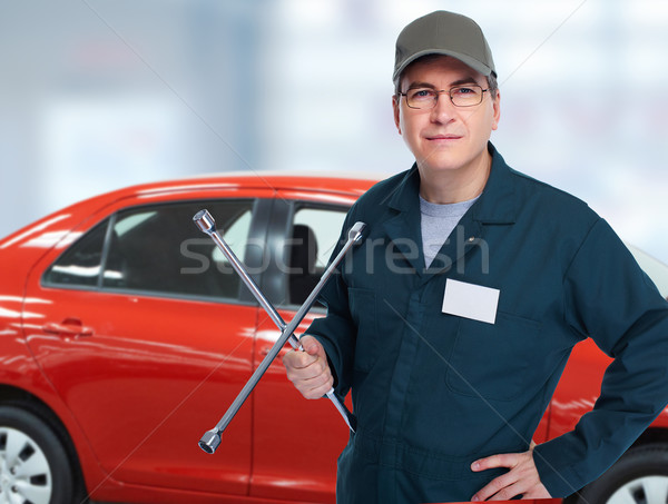 Auto mechanic with tire wrench in garage. Stock photo © Kurhan