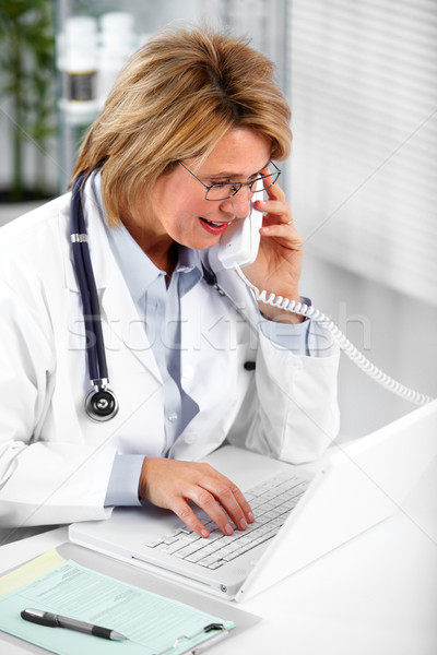 Stock photo: Mature doctor woman calling by phone.