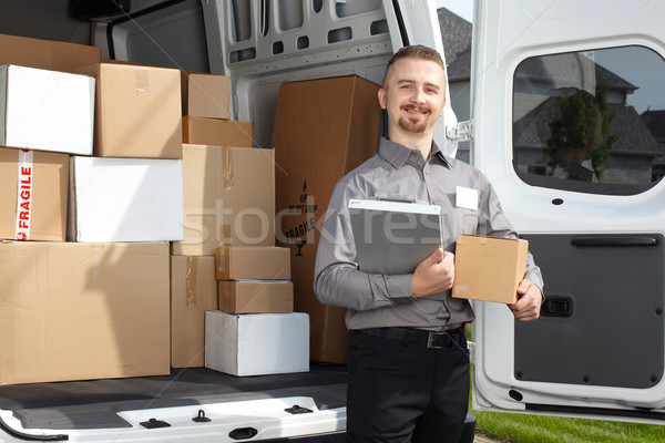 Stock photo: Young postman with parcel.