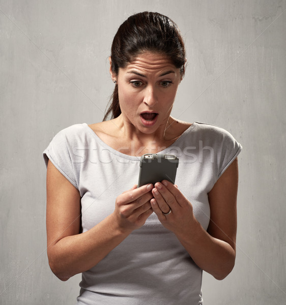 surprised uncontented woman with smartphone Stock photo © Kurhan