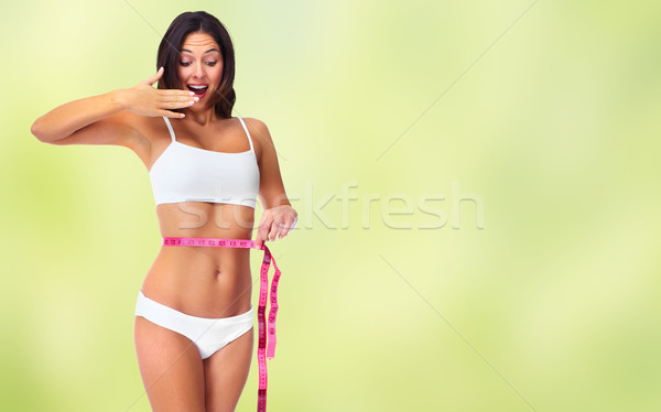 Woman with measuring tape over green background. Stock photo © Kurhan