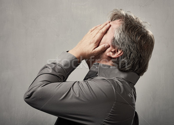 Baş ağrısı bunalımlı adam gri duvar yüz Stok fotoğraf © Kurhan