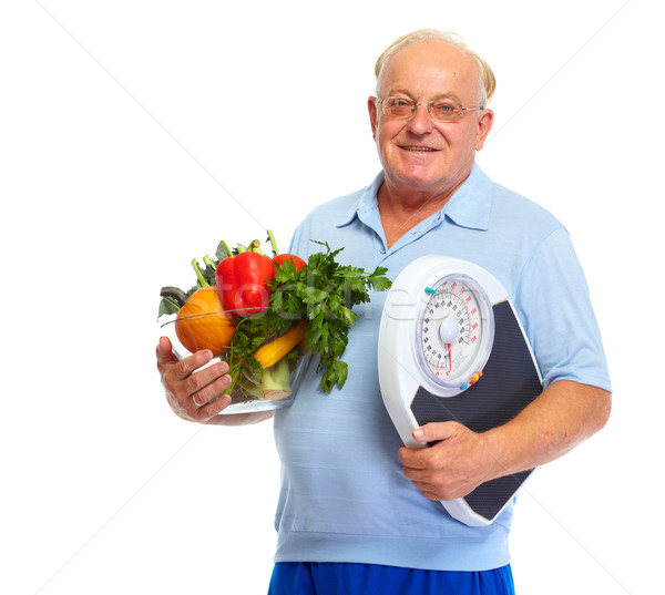 Senior man with scales and vegetables. Stock photo © Kurhan