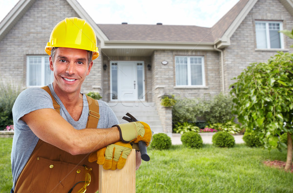 Stock photo: Handyman with wood and hammer.