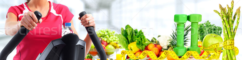 Young woman exercising on elliptical trainer. Stock photo © Kurhan