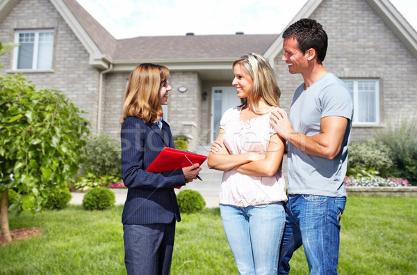 Real Estate agent woman with clients near new house. Stock photo © Kurhan