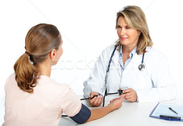 Doctor woman measuring patient blood pressure. Stock photo © Kurhan